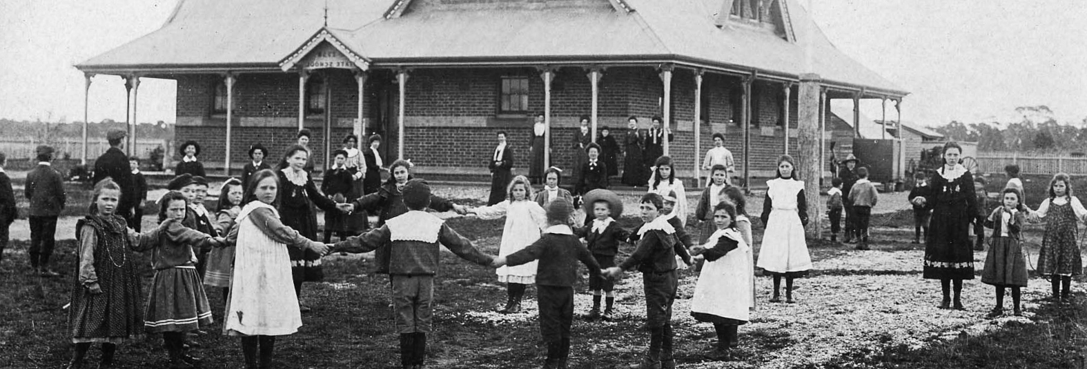 Education history unit, VPRS 14562/P10 Unit 1 Black and white photo, children playing outside of a school
