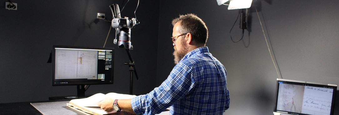 a man scanning records on a digital scanner