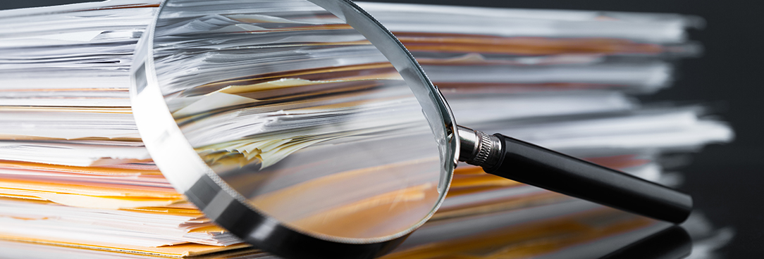 papers with a magnifying glass