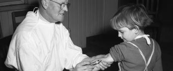 Black and white photo, doctor innoculating child