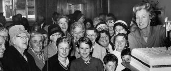 Black and white photo, crowd with a cake
