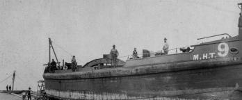 Black and white photo of a ship with crew