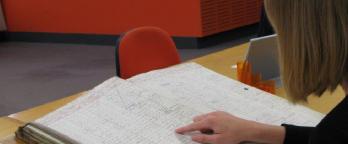 A volunteer reading an archival book 